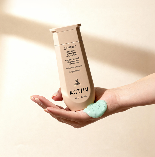 ACTIIV Remedy dandruff shampoo treatment held in hand with mint-colored formula, formulated with pyrithione zinc to cleanse scalp, reduce visible flakes, and support dry scalp balance.