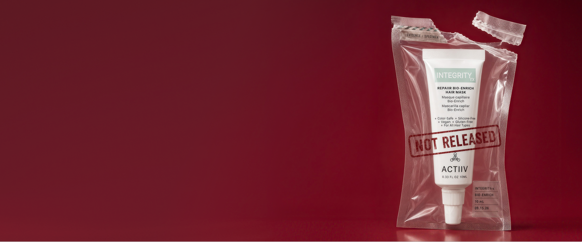 A tube of ACTIIV IntegrityRX Repaiir Hair Mask inside a clear plastic pouch with a torn top seal and a red 'NOT RELEASED' stamp, set against a solid dark red background.