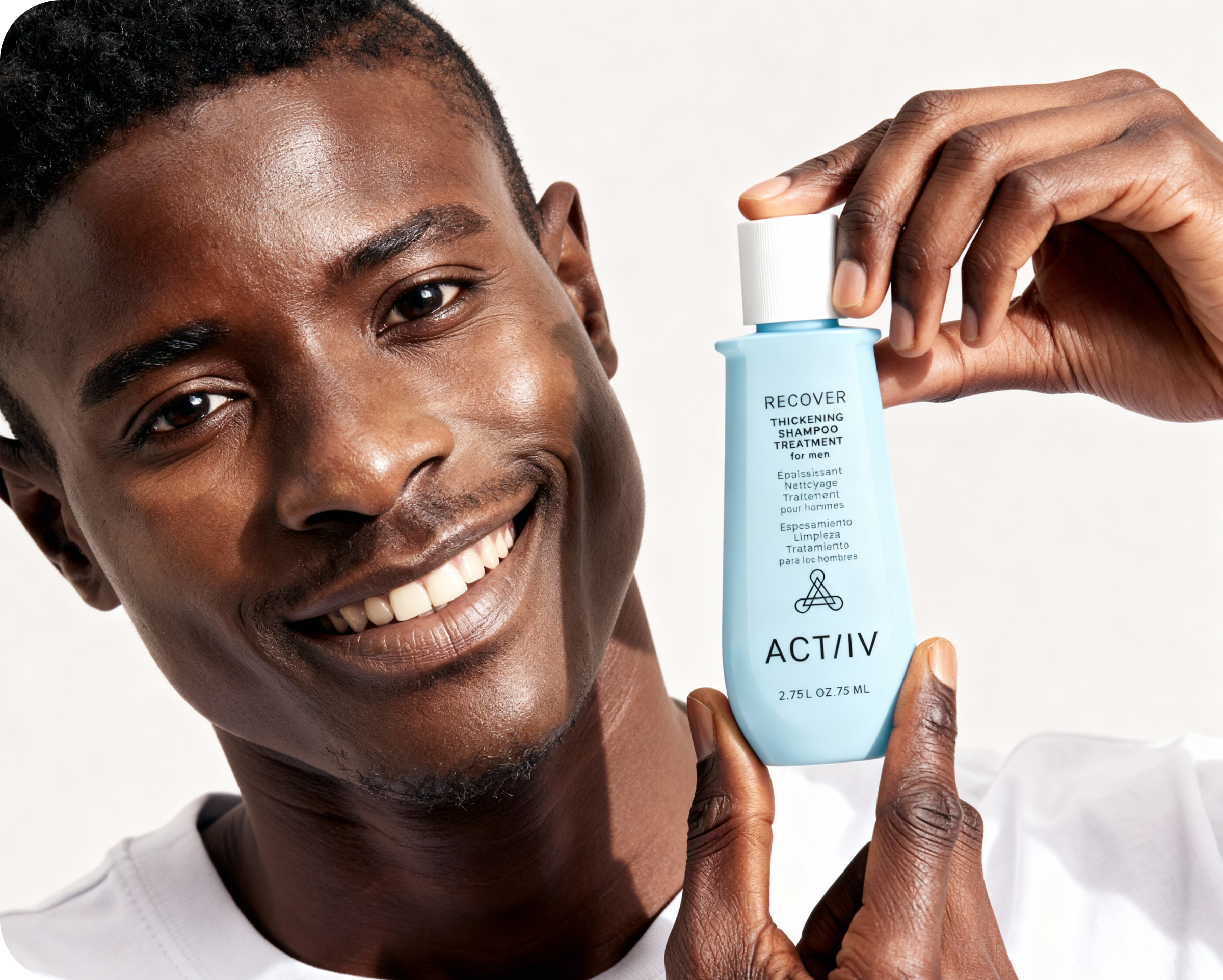 Man holding a bottle of ACTIIV recover thickening shampoo for men