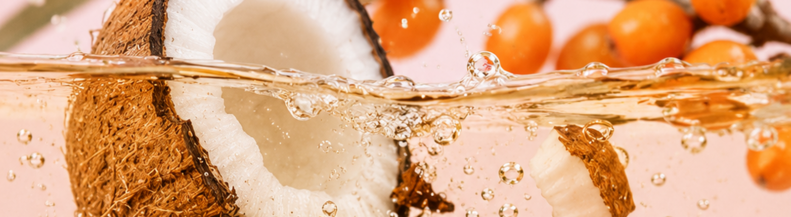 Coconut and botanical ingredients in nourishing oil representing plant-based conditioning ingredients for dry, damaged hair.