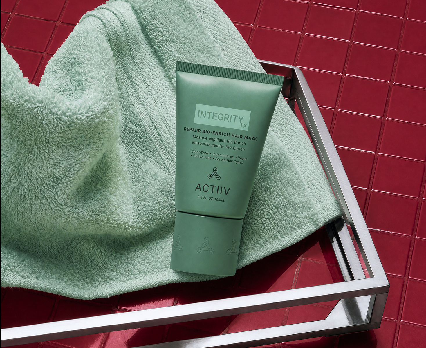 ACTIIV INTEGRITYrx Repair Bio-Enrich Hair Mask on a mint towel, a deep-conditioning hair mask designed to nourish, smooth and soften hair.